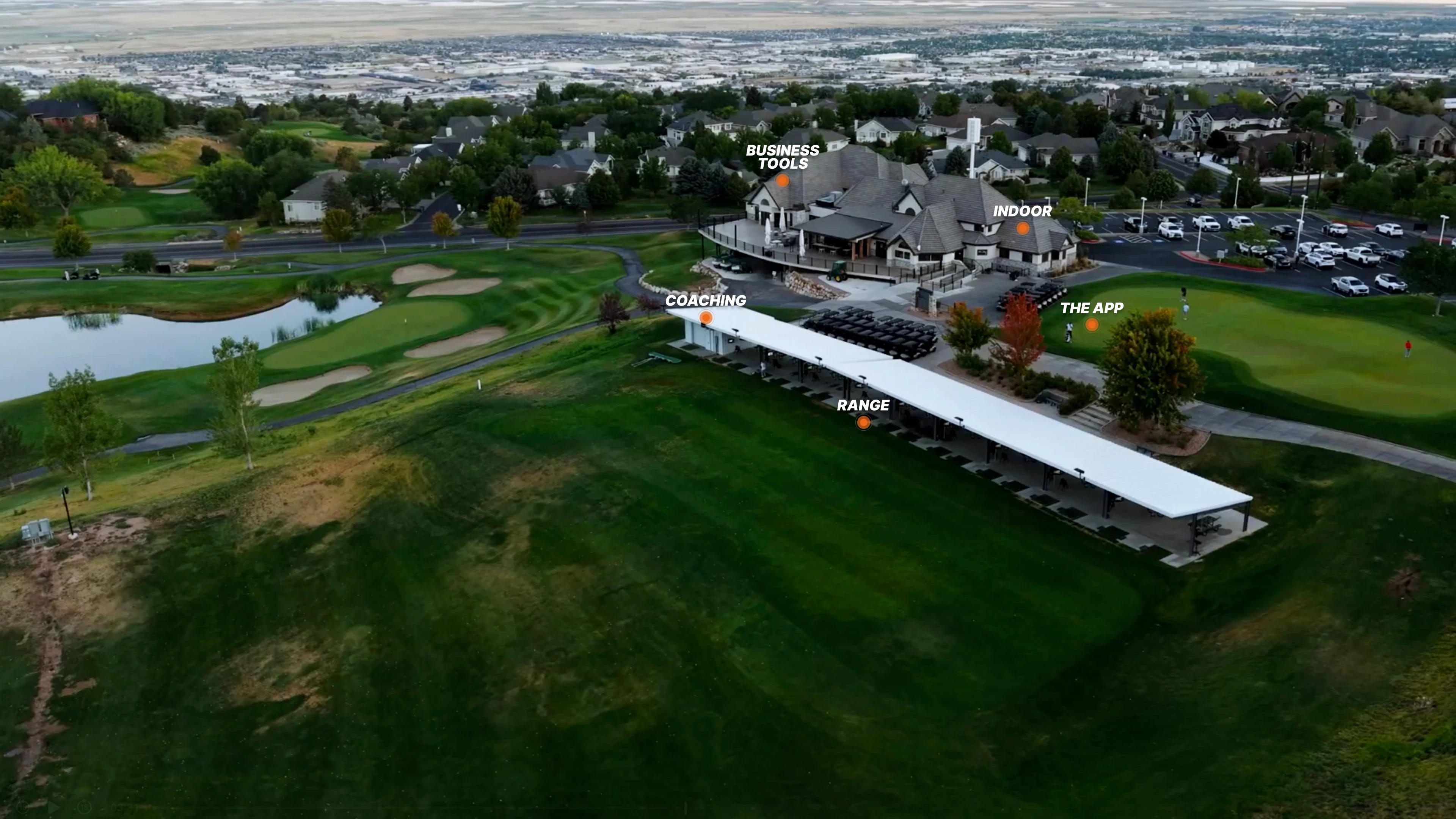 Aerial view of a golf facility with marked areas for business tools, coaching, an indoor area, a range, and an app, surrounded by greenery and buildings.