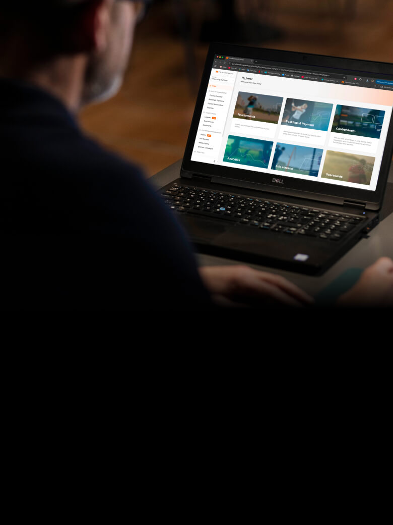 Person using a Dell laptop displaying Trackman Booking and Payments