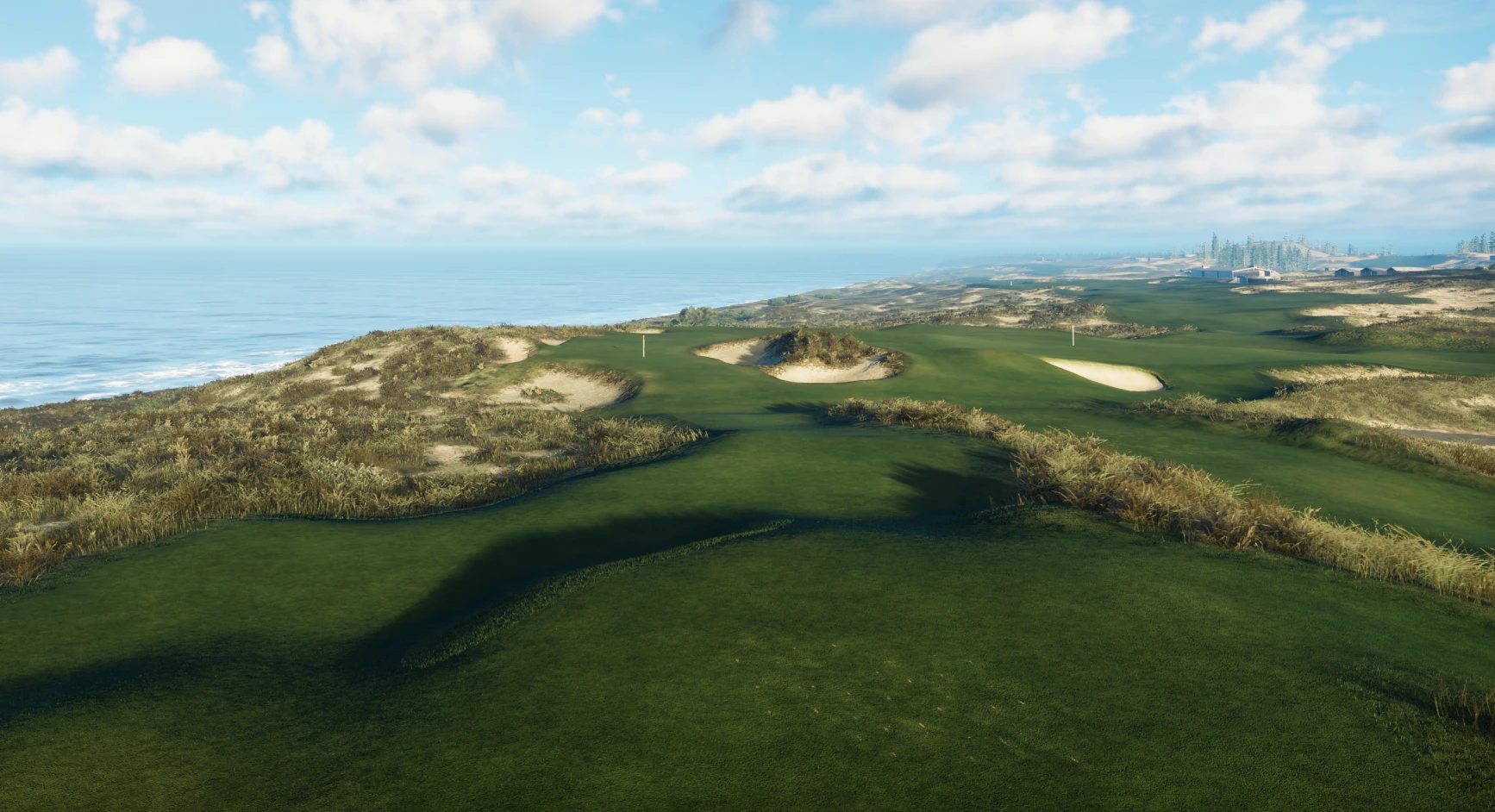 A coastal golf course with lush green fairways and sandy bunkers under a blue sky and scattered clouds. The ocean is visible on the horizon.