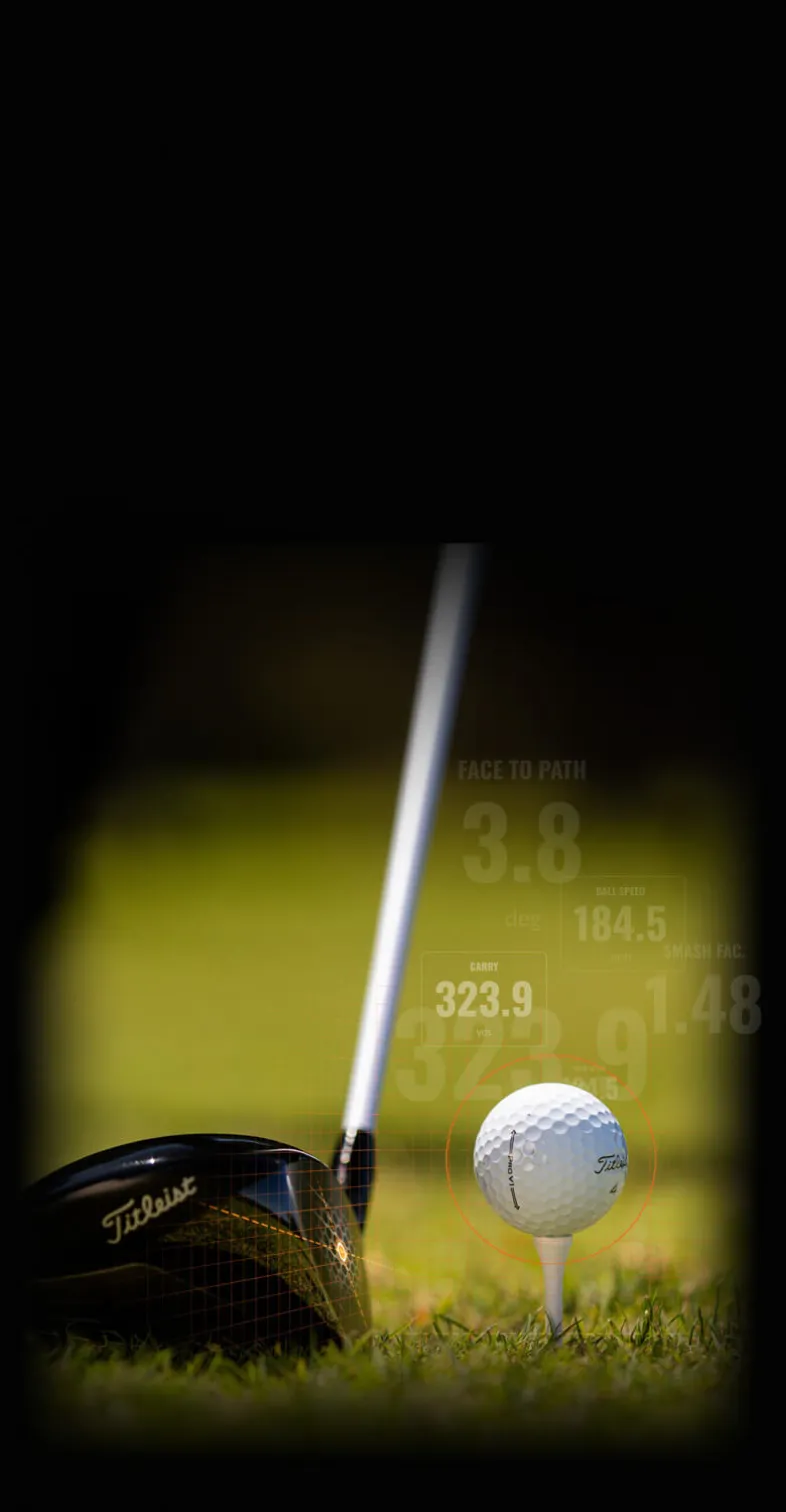 Close-up of a golf club and ball on grass, with performance stats in the background, including distance and speed measurements.